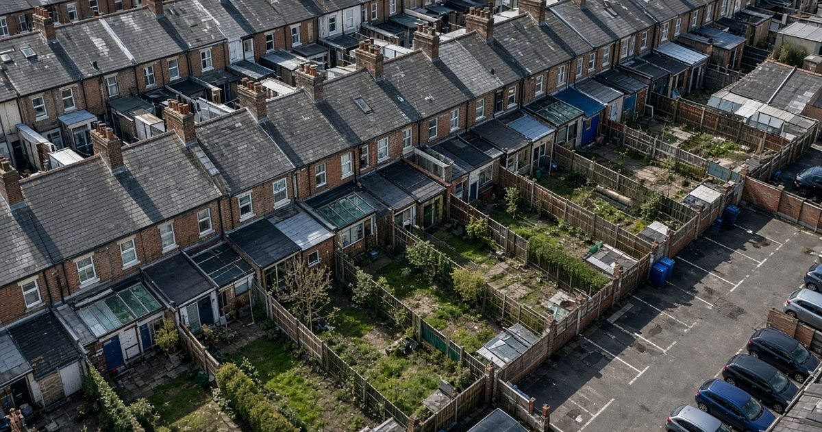 A terrace of British houses and their back gardens, seen from high above in daylight