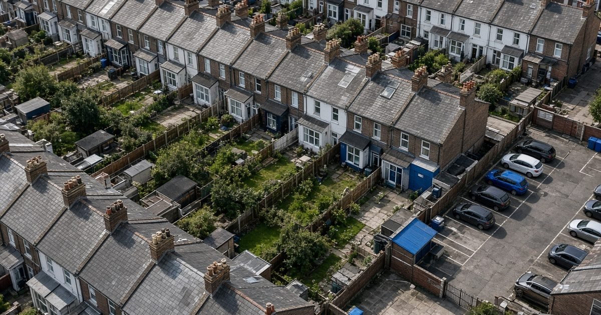 A terrace of British houses and their back gardens, seen from high above in daylight